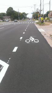A buffered bike lane on a state highway into town transitions to dashed lines at the intersections. Well executed design.